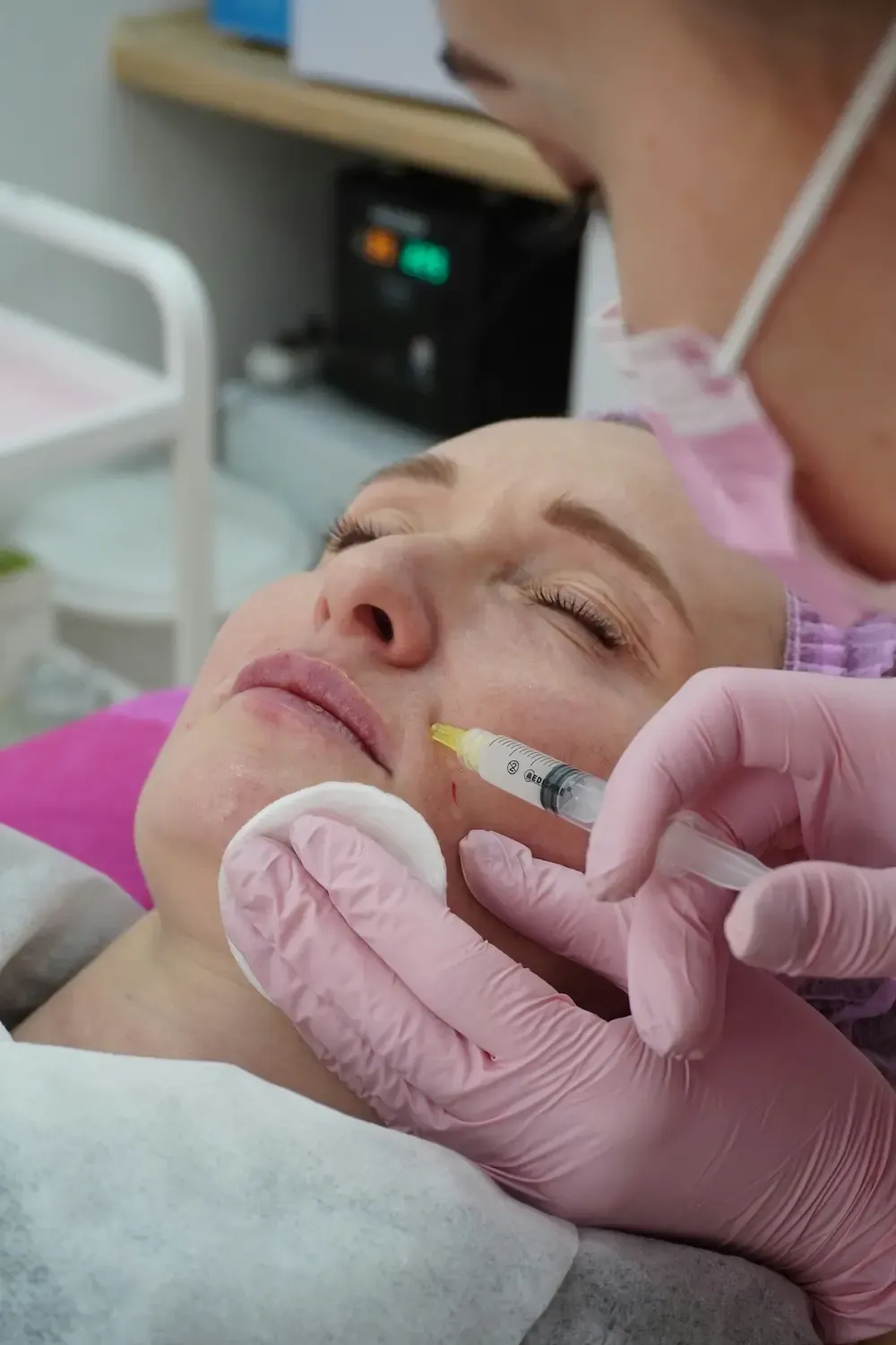 A female doctor injecting above a female patient's lips