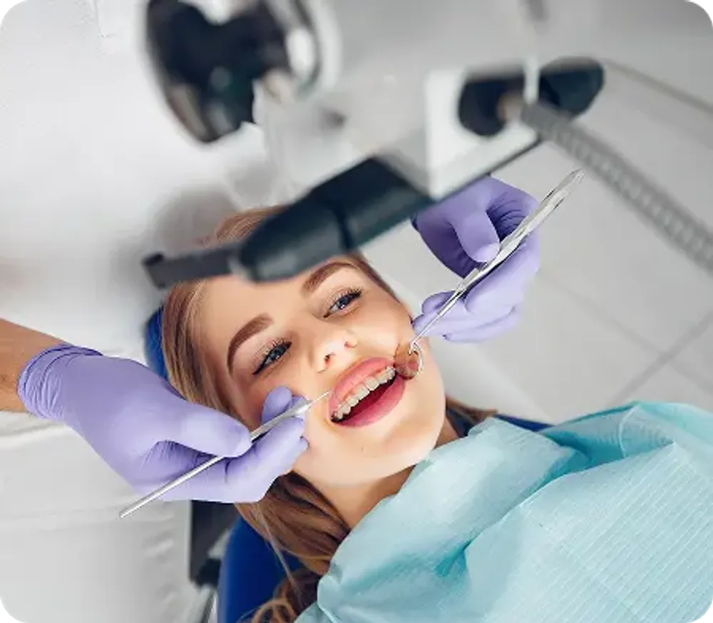 Dentist removing a patient’s tooth with forceps.