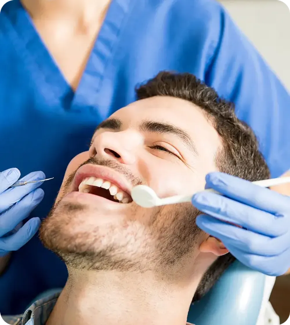 Male patient receiving a dental filling treatment, showcasing a professional restorative dentistry procedure.